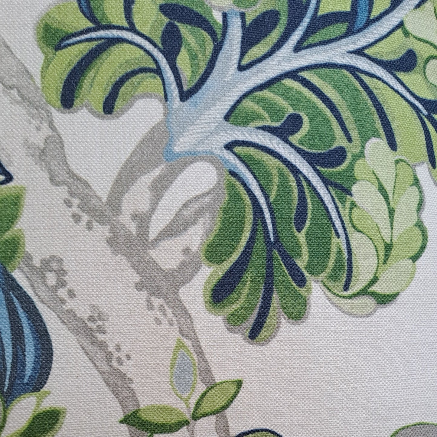 Close-up of fabric with green and blue leaf pattern on a white background