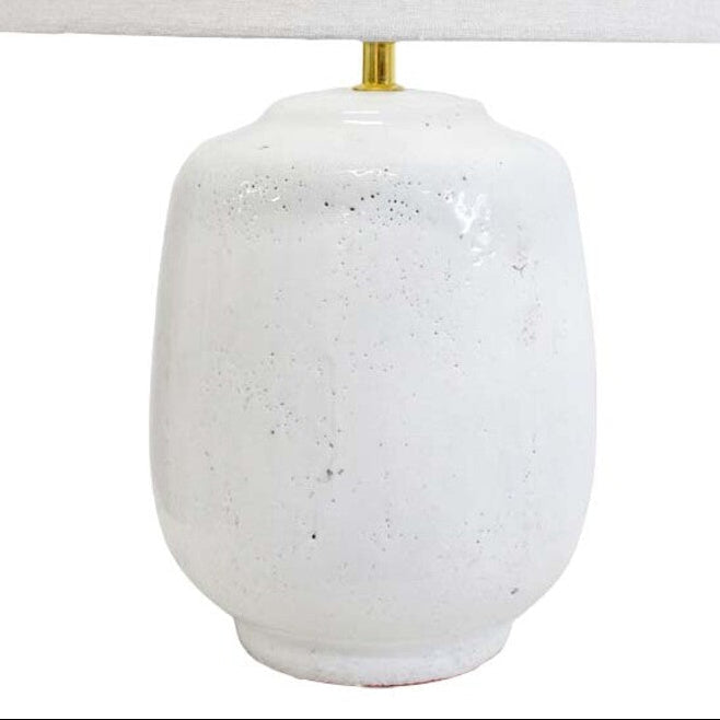 White textured table lamp with a white lampshade on a white background