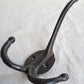 Black metal double hook on a textured beige background