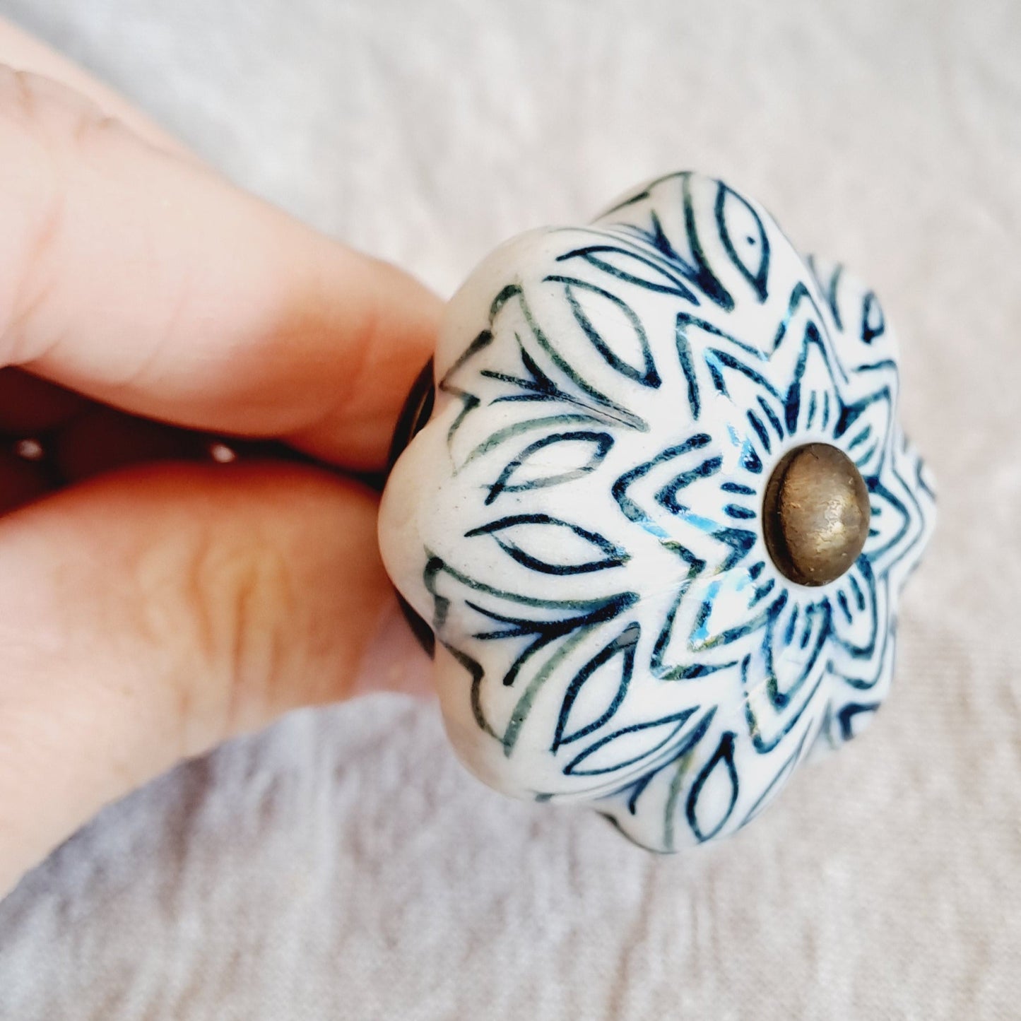 Hand holding a ceramic knob with blue and white pattern
