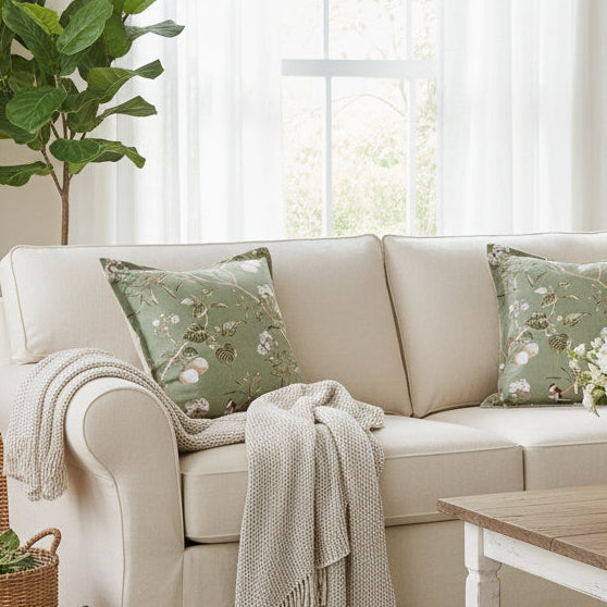Green floral pillow on a gray sofa