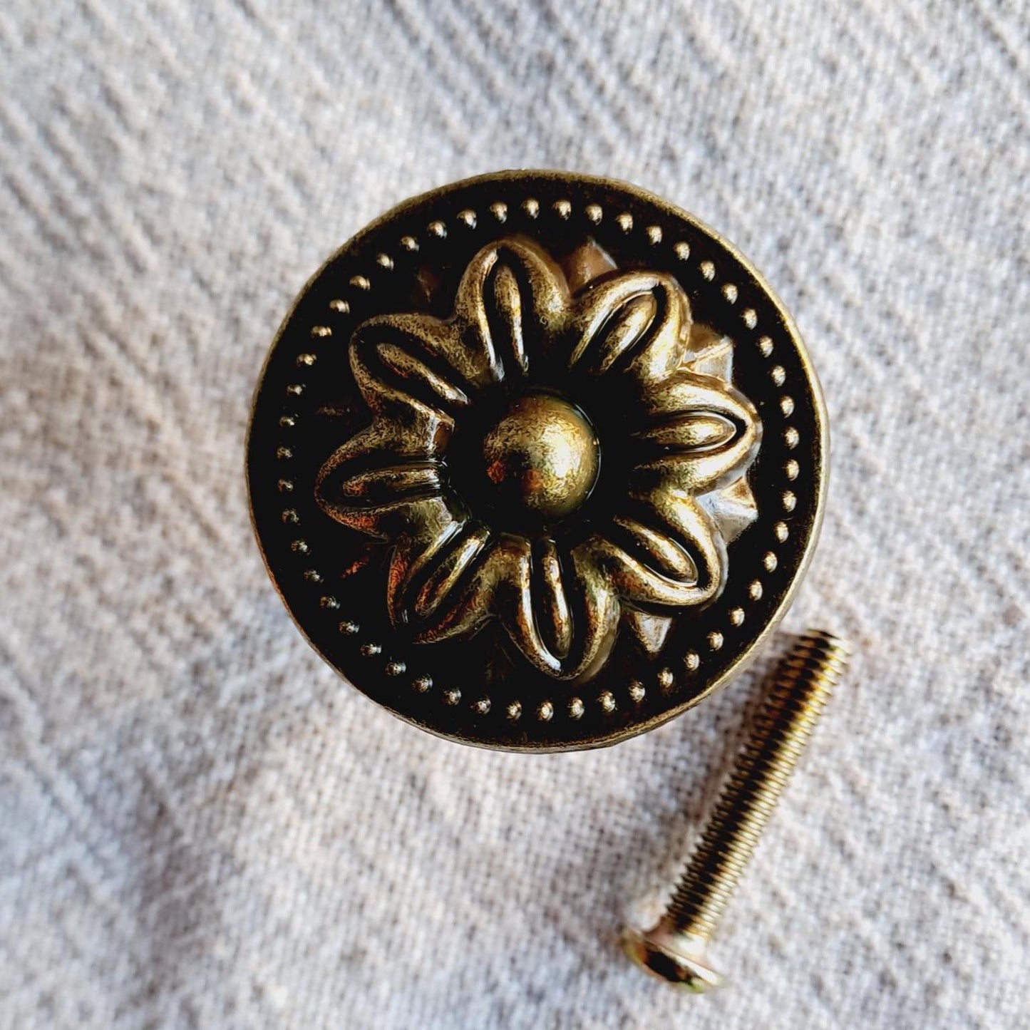 Decorative brass knob on a textured fabric background