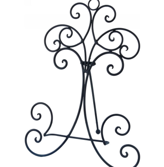 Decorative metal plant stand with intricate designs on a white background
