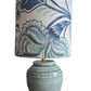 Table lamp with a decorative blue and white floral patterned shade on a white background