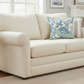 Beige sofa with a decorative pillow in a living room setting