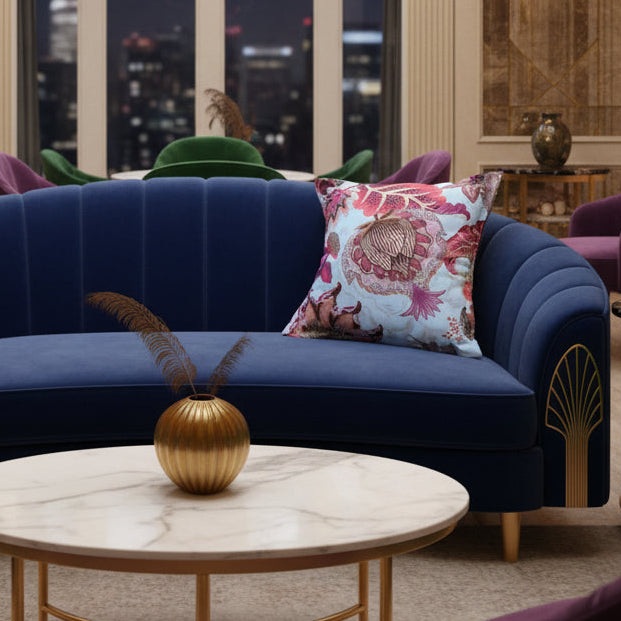 A square decorative throw pillow featuring a botanical and floral pattern in shades of pink, purple, and brown on a pale blue background.