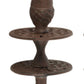 Decorative metal object with acorn design on a white background