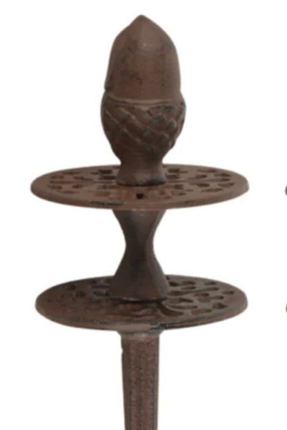 Decorative metal object with acorn design on a white background