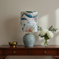 Table lamp with a decorative floral-patterned shade and textured base on a white background