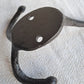 Black metal double hook on a textured white background