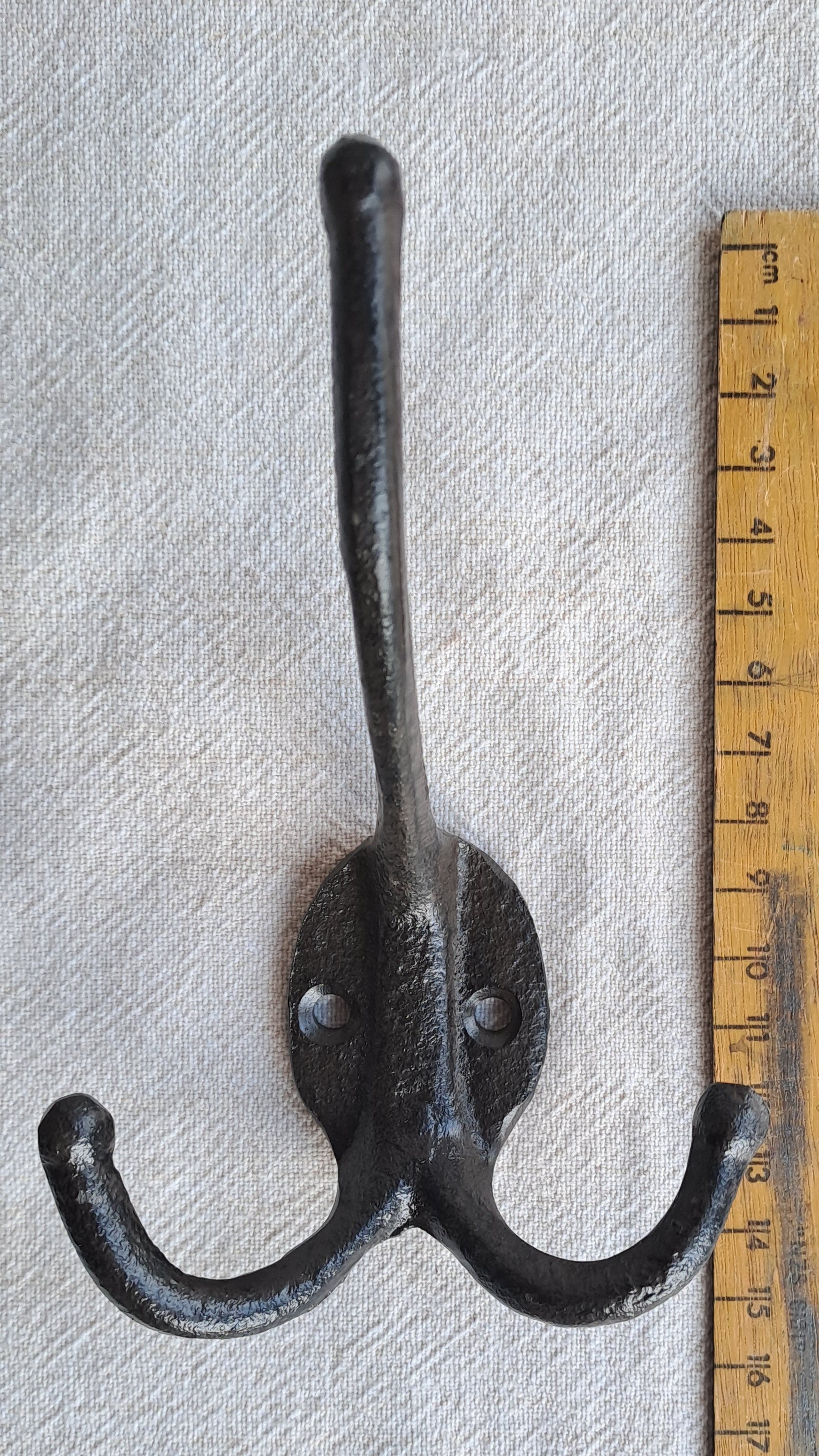 Double wall hook with a ruler for scale on a gray background